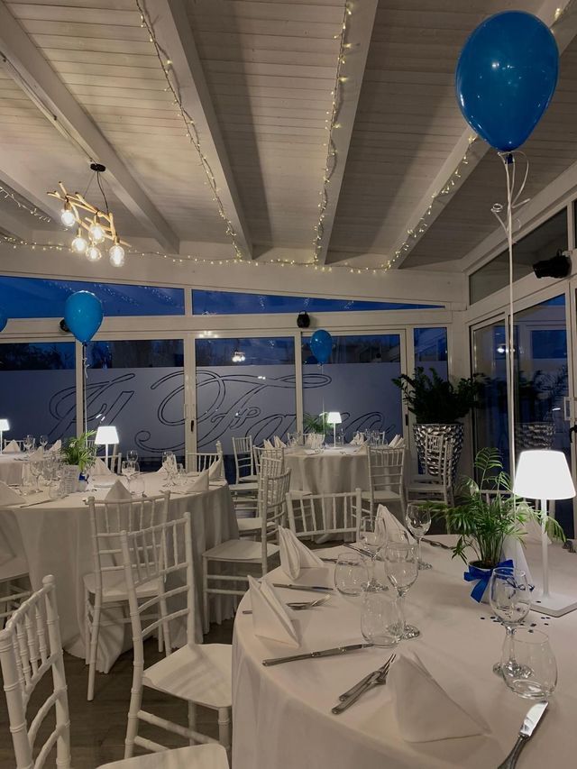 Una stanza con tavoli e sedie e palloncini blu