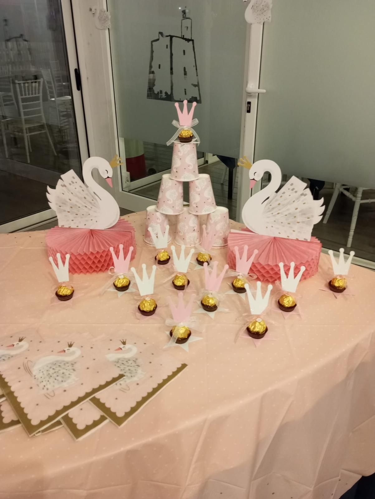 Un tavolo decorato con cigni e corone per una festa di compleanno da principessa.