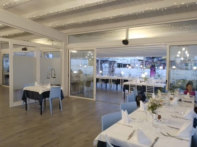 Un ristorante con tavoli e sedie e una donna seduta a un tavolo