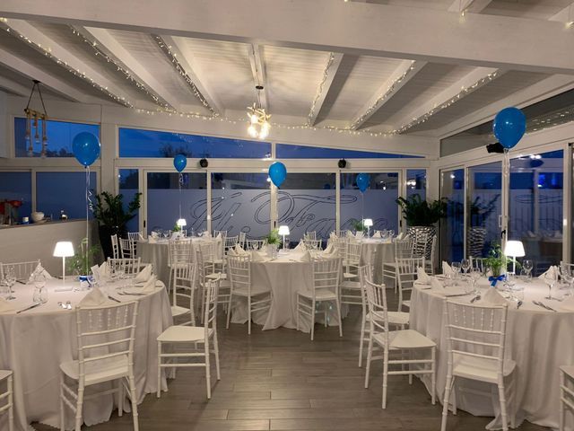 Una stanza con tavoli e sedie bianchi e palloncini blu sul soffitto.