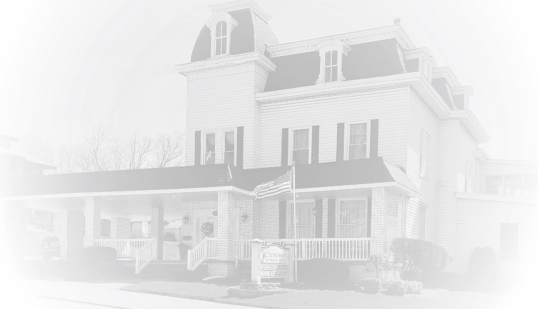 A white Victorian-style house with a porch and tower, seen in a bright, washed-out view.