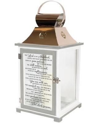 White decorative lantern with a gold handle and candle-lit plaque text on the front