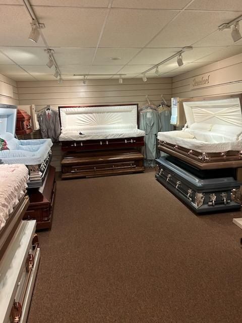 Mattress showroom with several open white mattresses on display in a carpeted room