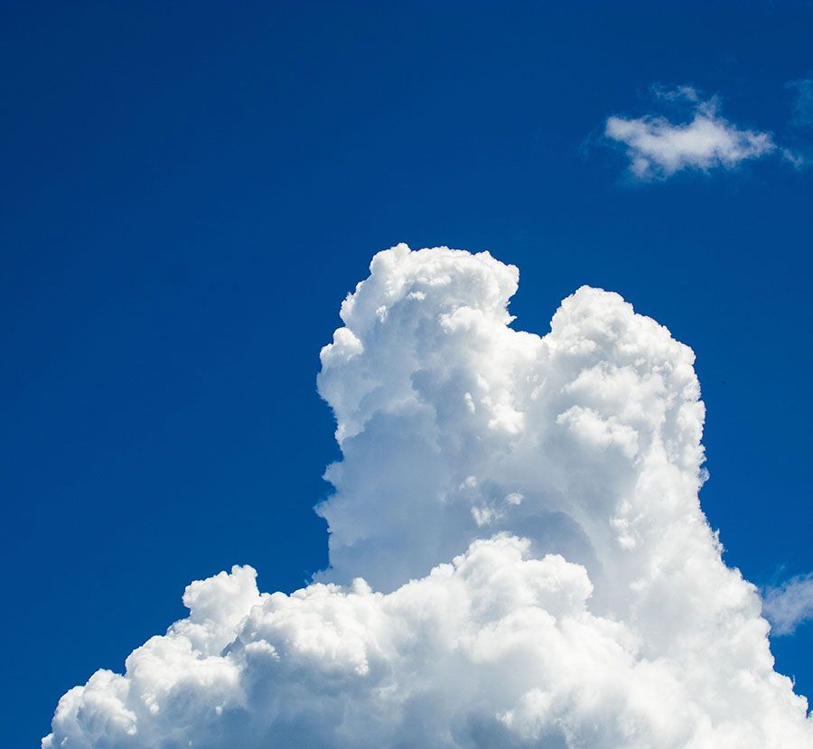 Bright white cumulus clouds against a clear deep blue sky
