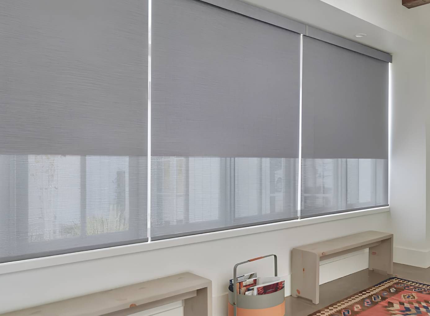 Hunter Douglas Designer Roller Shades covering three windows in a modern home.