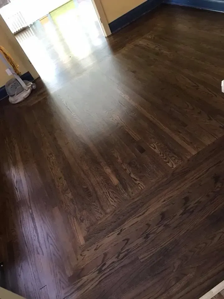 Dark stained hardwood floor with a herringbone border.