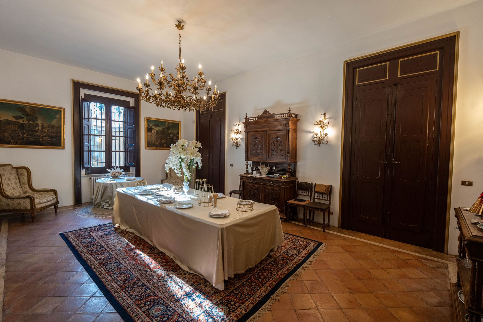 Una grande sala da pranzo con un lungo tavolo e un lampadario.