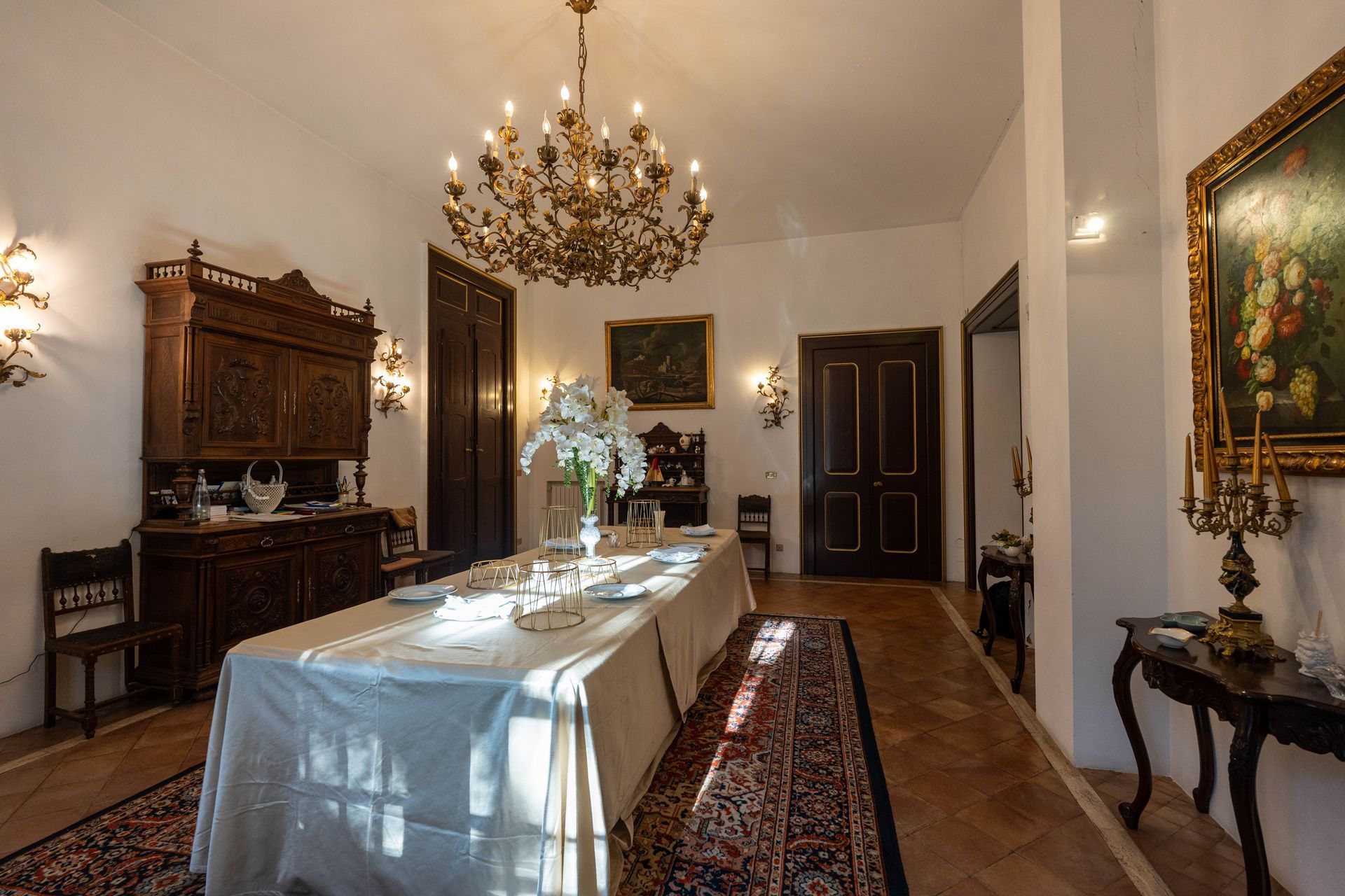Una sala da pranzo con un lungo tavolo e un lampadario.