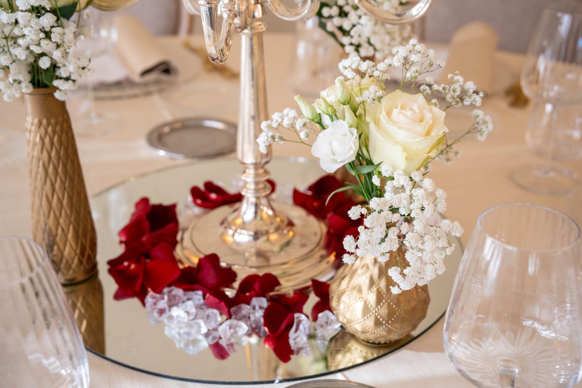 Un tavolo con sopra un candelabro e vasi di fiori.