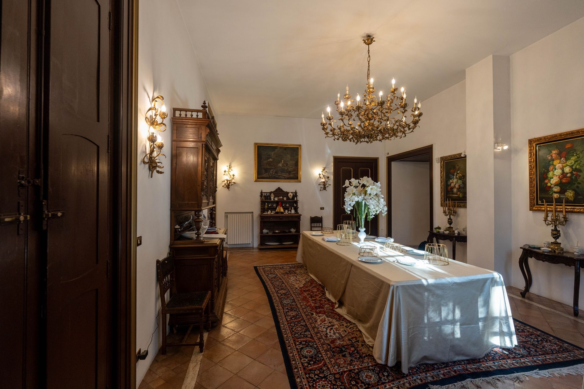 Una sala da pranzo con un lungo tavolo e un lampadario.