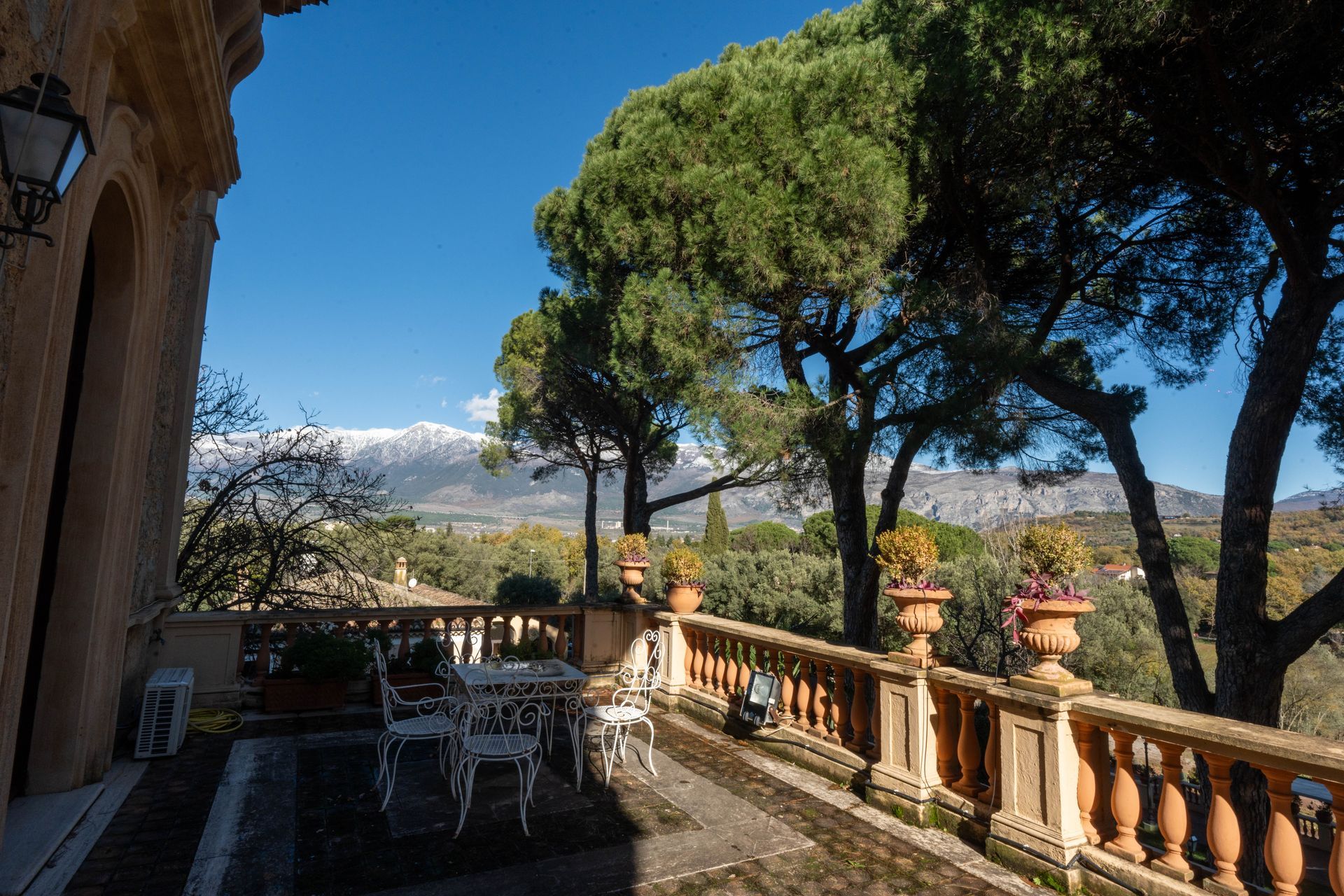 C'è un balcone con vista sulle montagne e sugli alberi.