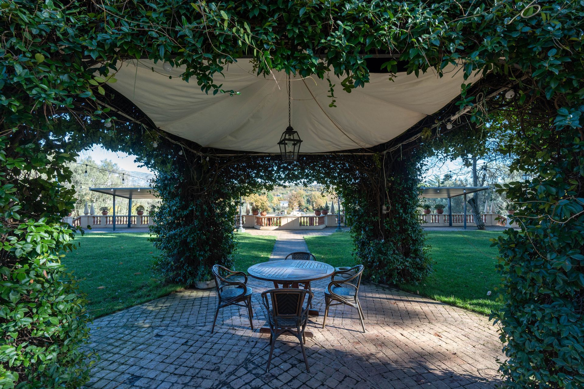 Un gazebo con un tavolo e delle sedie sottostanti