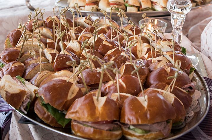 A tray of sandwiches with toothpicks on them on a table.