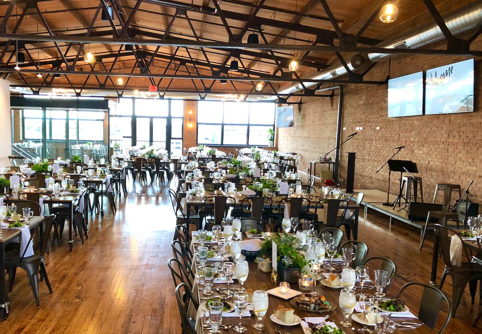 A large room with tables and chairs set up for a wedding reception.