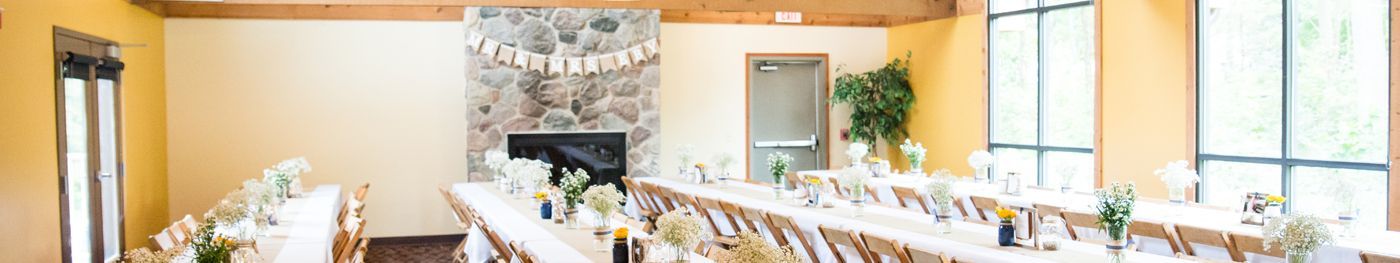 A long table and chairs in a room with a fireplace.