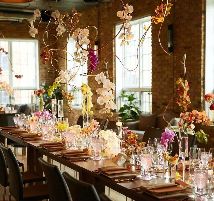 A long table with flowers and glasses on it