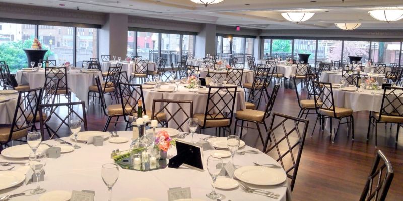 A large room with tables and chairs set up for a wedding reception.