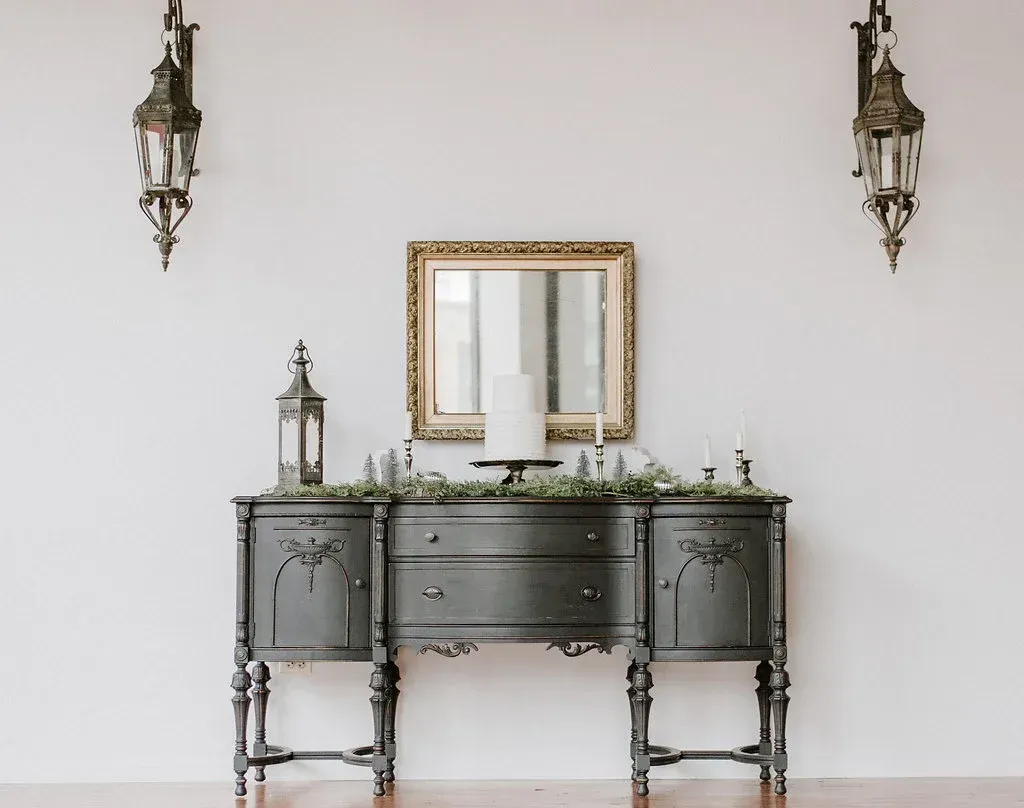 A dresser with a mirror and candles on it in a room.