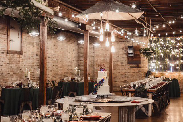 A bride and groom are sitting at a table at a wedding reception.