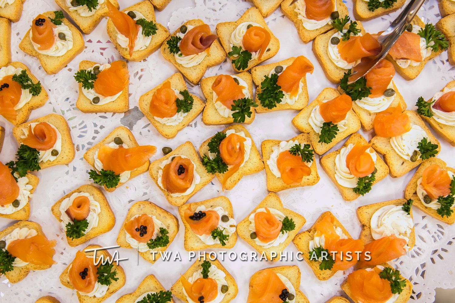 A tray of crackers with smoked salmon and cheese on them