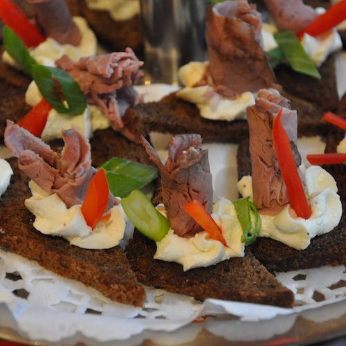A tray of sandwiches with meat and vegetables on them