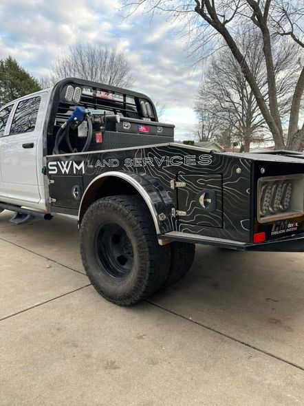 White off-road truck with custom black bed and large tires parked in a driveway