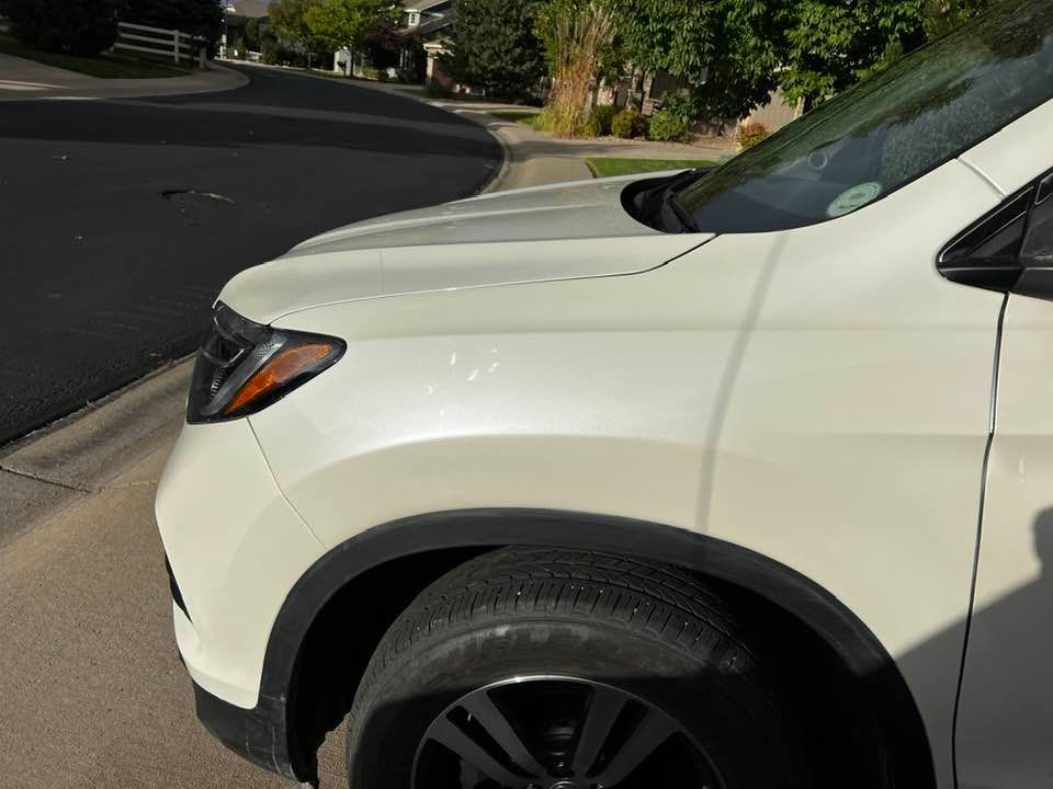 A white suv is parked on the side of the road.
