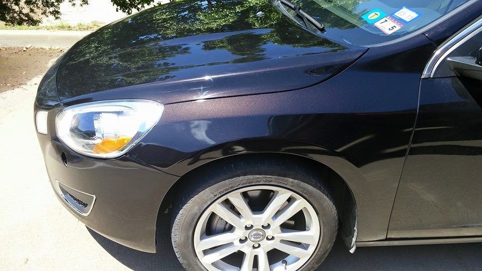 A black car is parked on the side of the road.