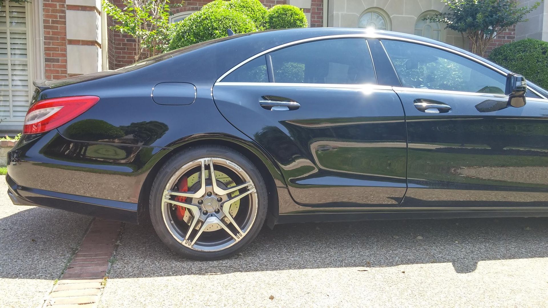 A black mercedes benz is parked in a driveway