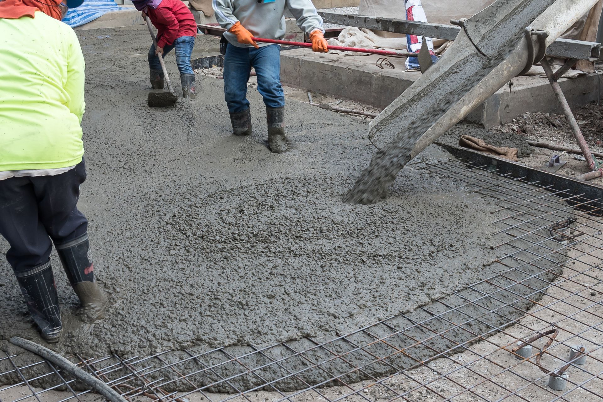 Workers pour and smooth concrete, creating a strong, reinforced base
