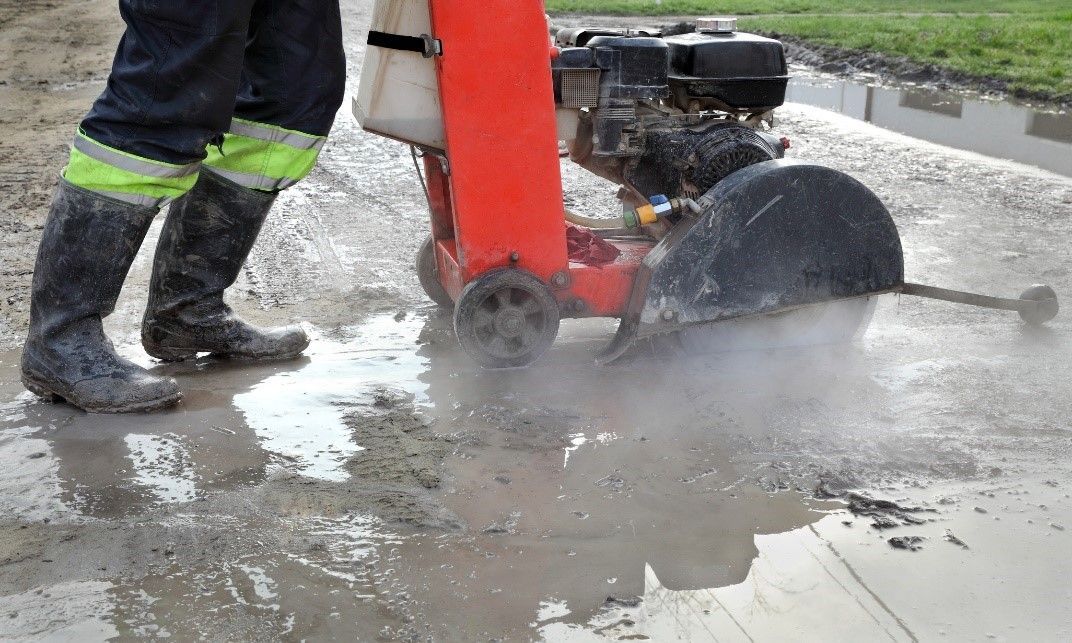 A person using a machine to grind concrete | Graham Construction | Concrete Construction Services in