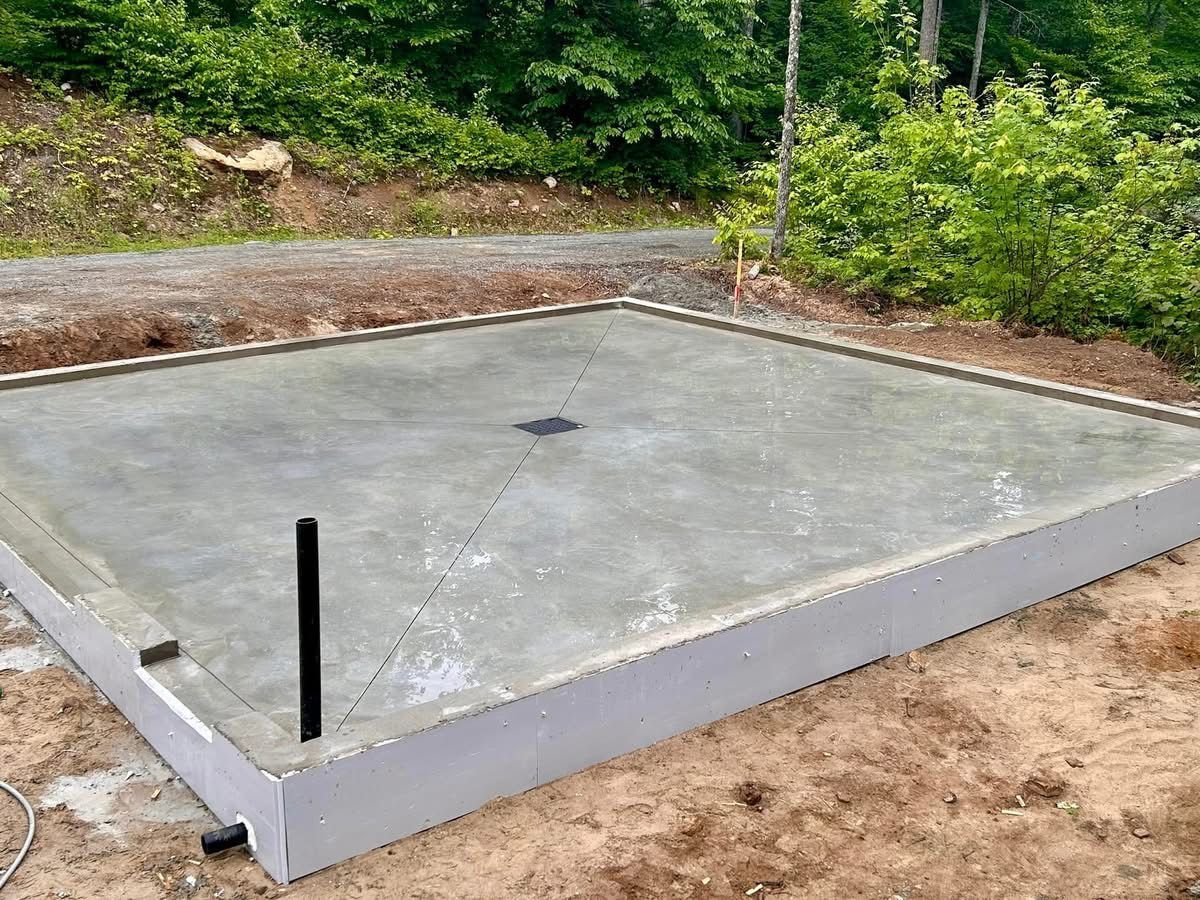 Une base en béton pour une maison est en train d'être construite dans la terre.