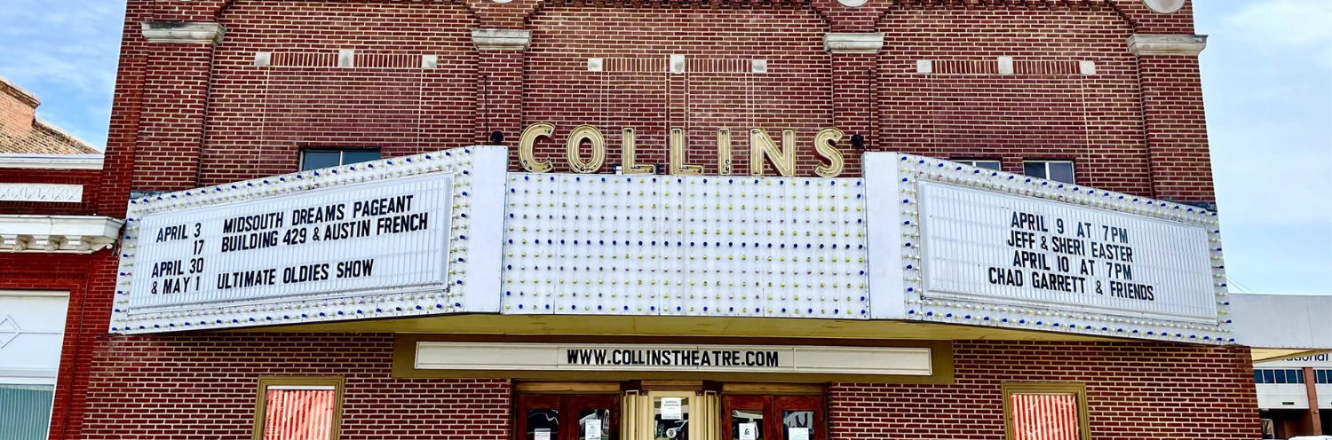 Marquee on a brick theater facade reading “COLLINS” with movie posters and a striped awning