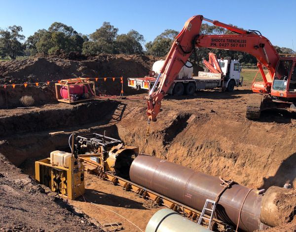 A large orange excavator is working on a construction site