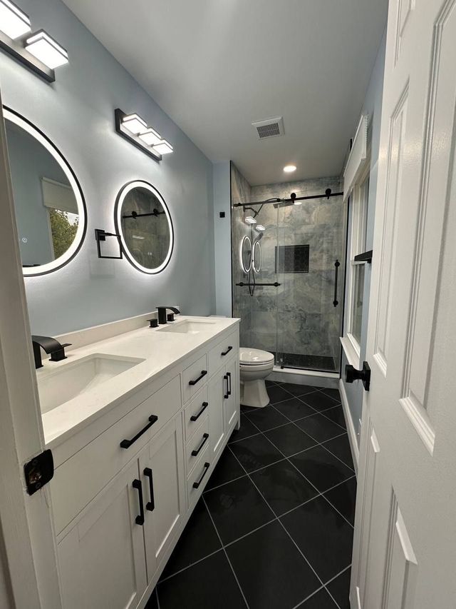 Finished Elkridge, MD bathroom with white double vanity and walk-in shower