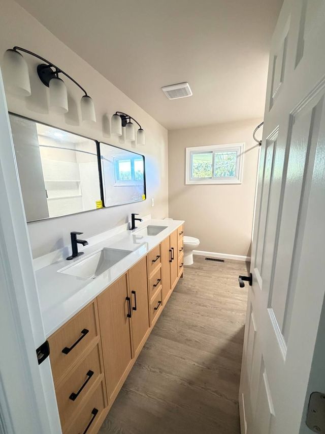 Finished Westminster, MD bathroom with oak double vanity and black fixtures