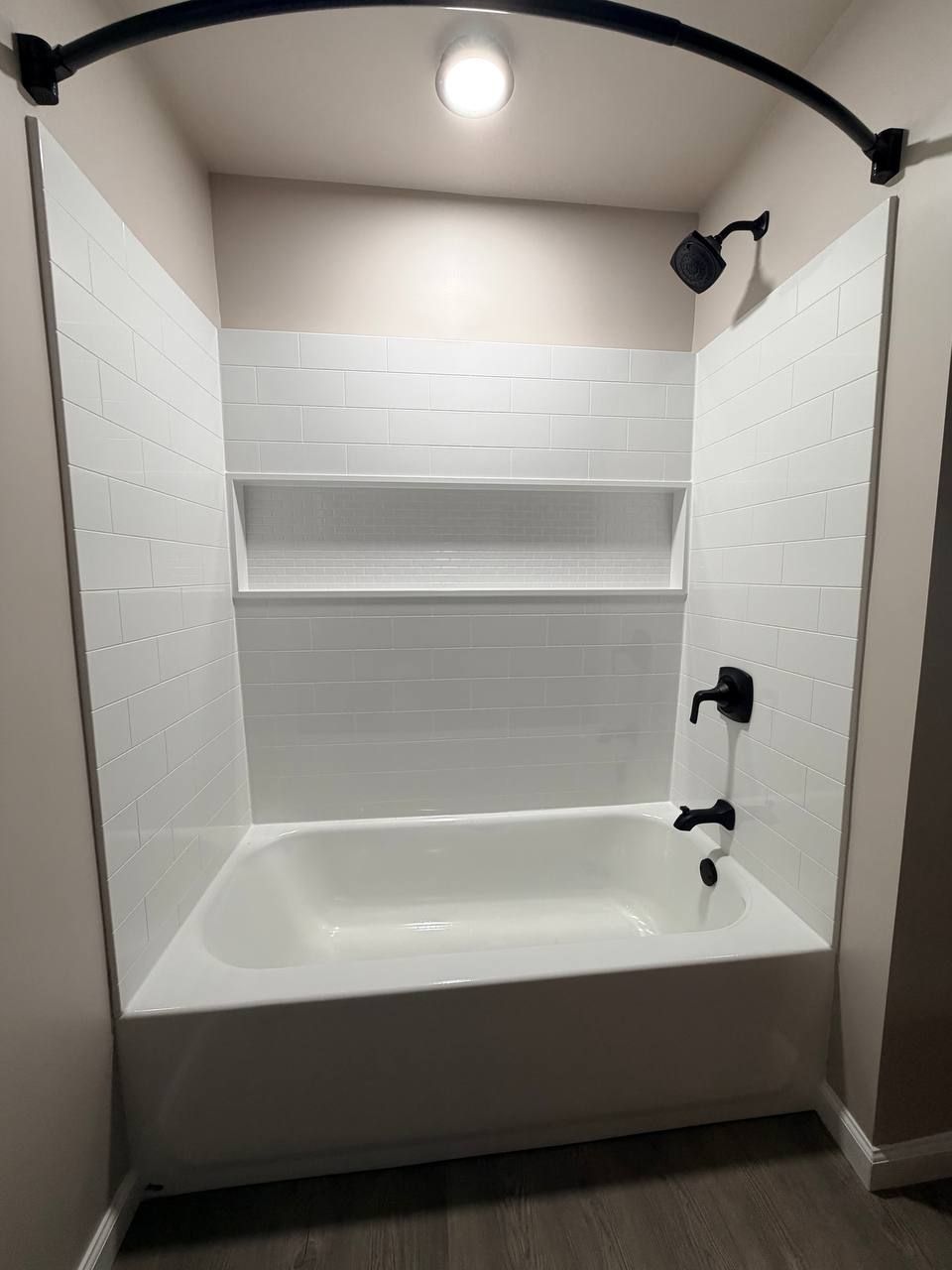 White tub and shower with full-width niche in a Westminster, MD bathroom