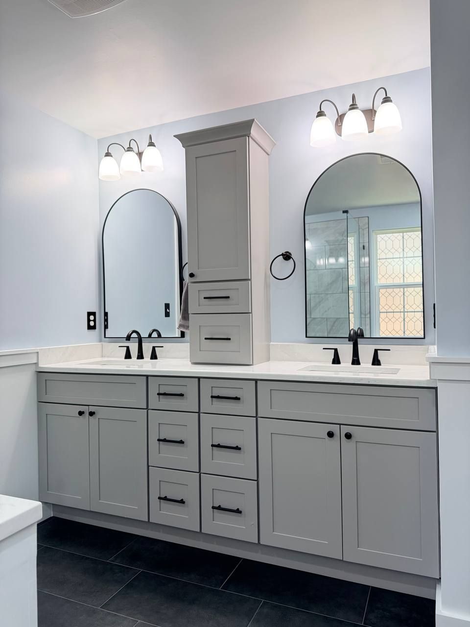 Professional bathroom remodel in Clarksville MD featuring double vanity with gray shaker cabinets, white quartz countertop, and arched mirrors by Handyman on Demand