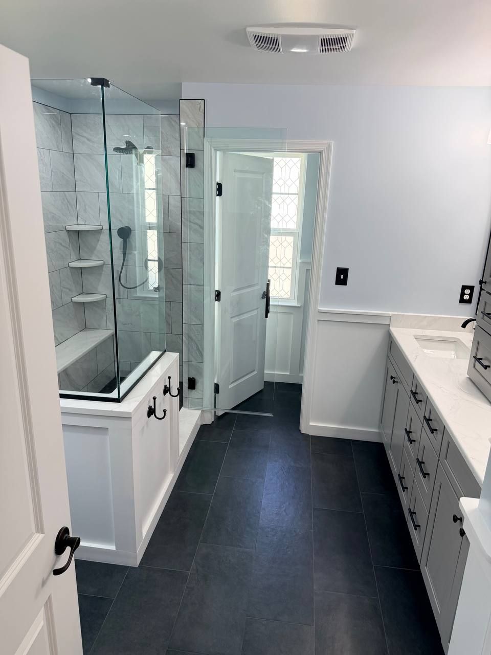 Licensed bathroom remodeling contractor in Clarksville MD — custom walk-in glass shower, vanity, and dark large format floor tile renovation by Handyman on Demand