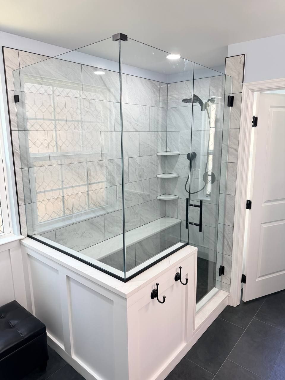 Affordable bathroom renovation in Clarksville Maryland with frameless glass shower, marble tile surround, built-in bench, and matte black fixtures by local contractor Handyman on Demand