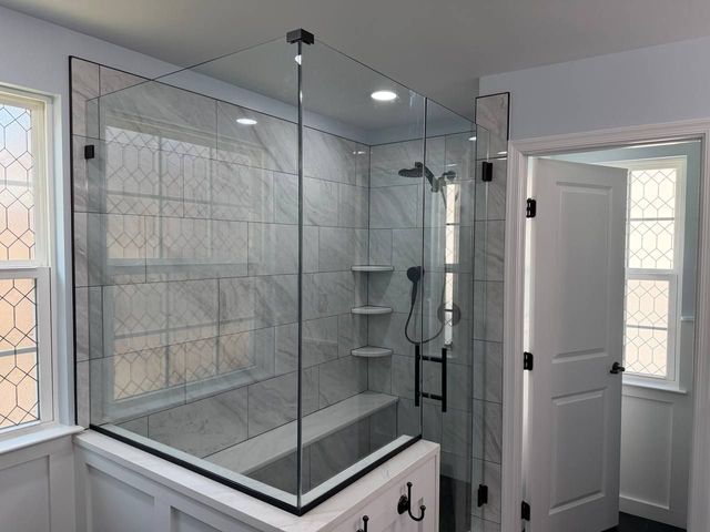 Walk-in shower with frameless glass and a built-in bench