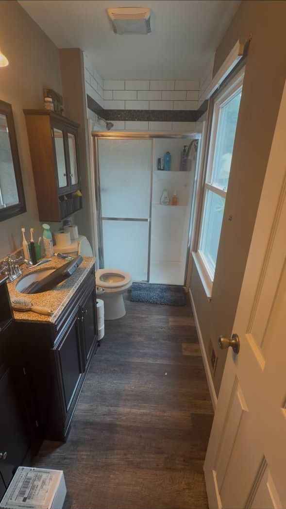 Elkridge, MD bathroom before remodeling with dark single vanity, wall cabinet and fiberglass shower stall