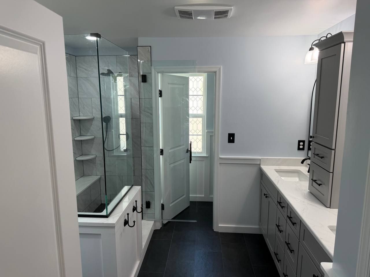Full bathroom renovation and remodel in Clarksville Maryland with marble tile walk-in shower, double vanity, and dark slate large format floor tile by Handyman on Demand