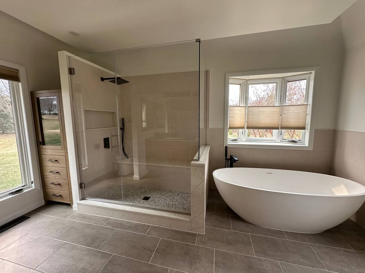 Full master bathroom remodel and renovation in Clarksville MD featuring walk-in glass shower, freestanding soaking tub, and custom built-in storage by Handyman on Demand
