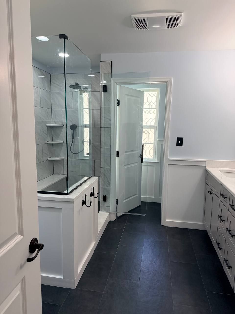 Licensed master bathroom remodeling in Clarksville MD with marble tile walk-in shower, gray shaker vanity, and dark slate large format floor tile by Handyman on Demand