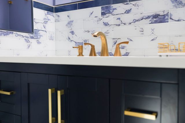 Gold faucet and fixtures on a navy vanity, a Handyman on Demand project