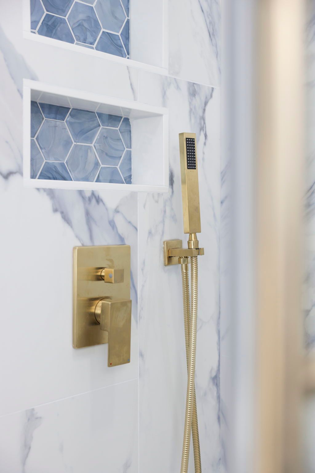 Bathroom remodel with brushed gold shower fixtures and marble tile in Baltimore County, MD
