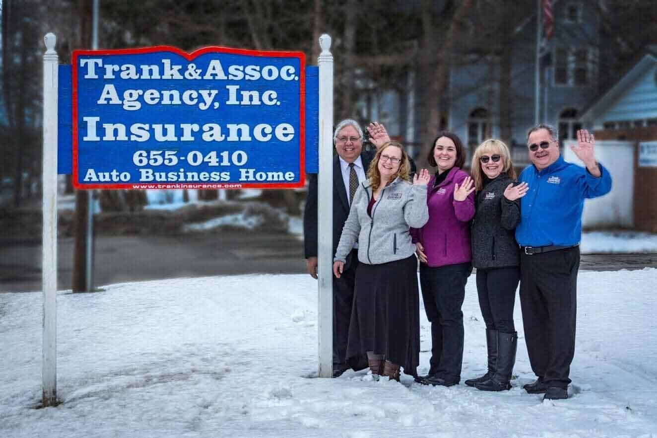 Five people wave in front of a blue Five people wave in front of a blue