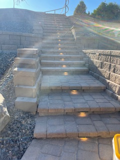 Outdoor stone steps leading uphill between stone retaining walls.