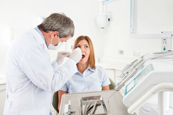 © adobeStock / Taras Grebinet Zahnarzt im Notdienst behandelt eine Patientin